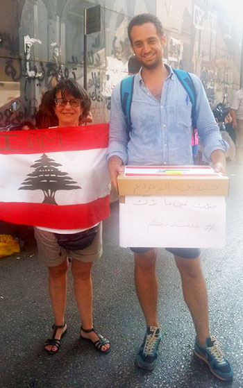 شاب يحمل صندوق اقتراع ويجول بين المتظاهرين في بيروت